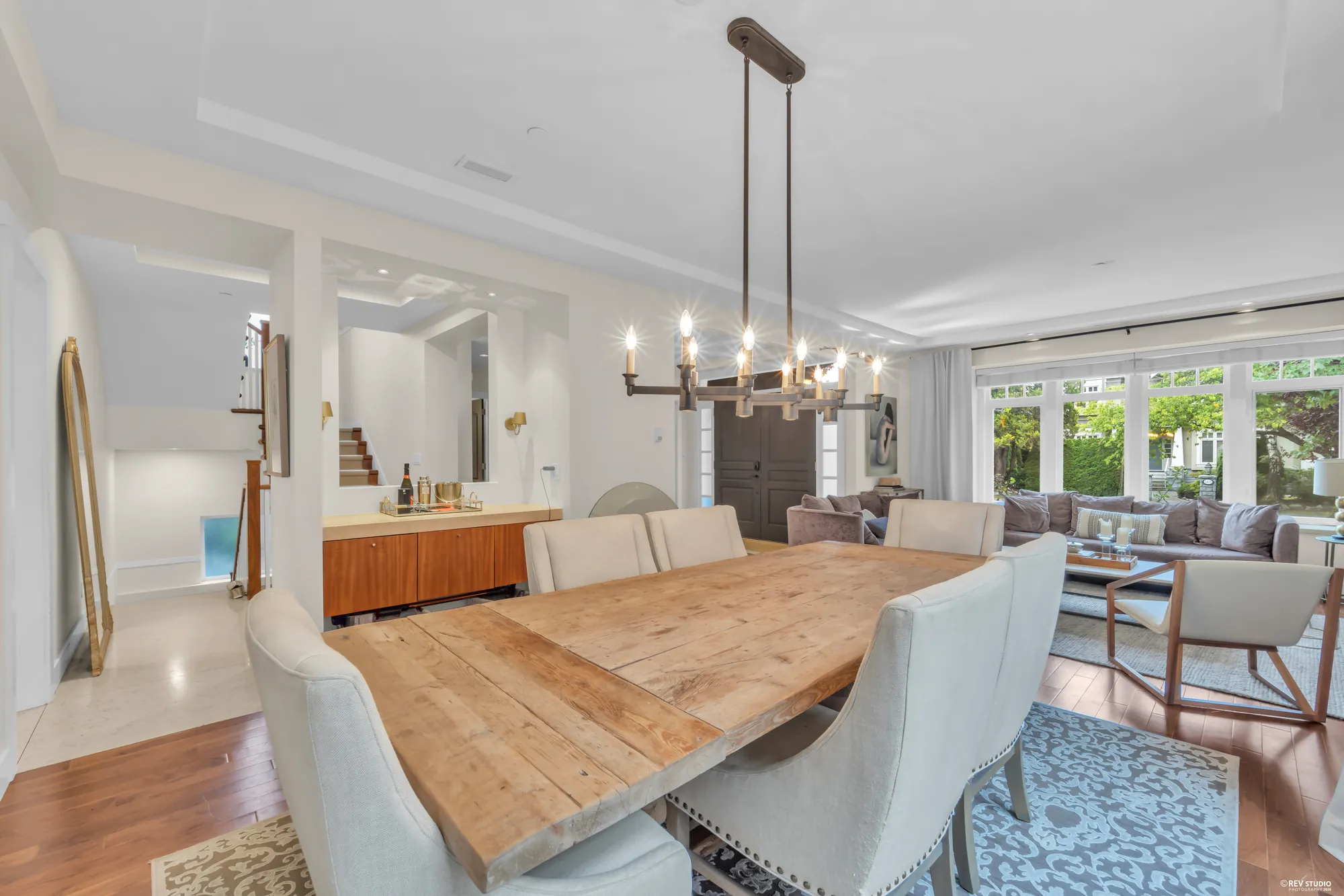 The dining table under its chandelier, the living room and the front windows beyond