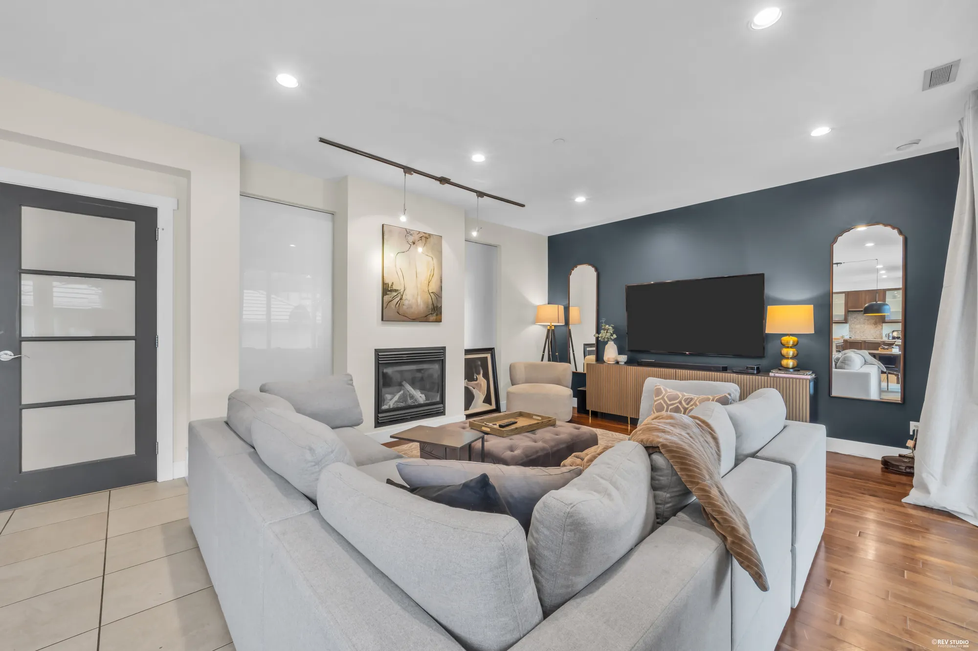 The family room from the kitchen side, the fireplace at left, the black-framed door to the hall