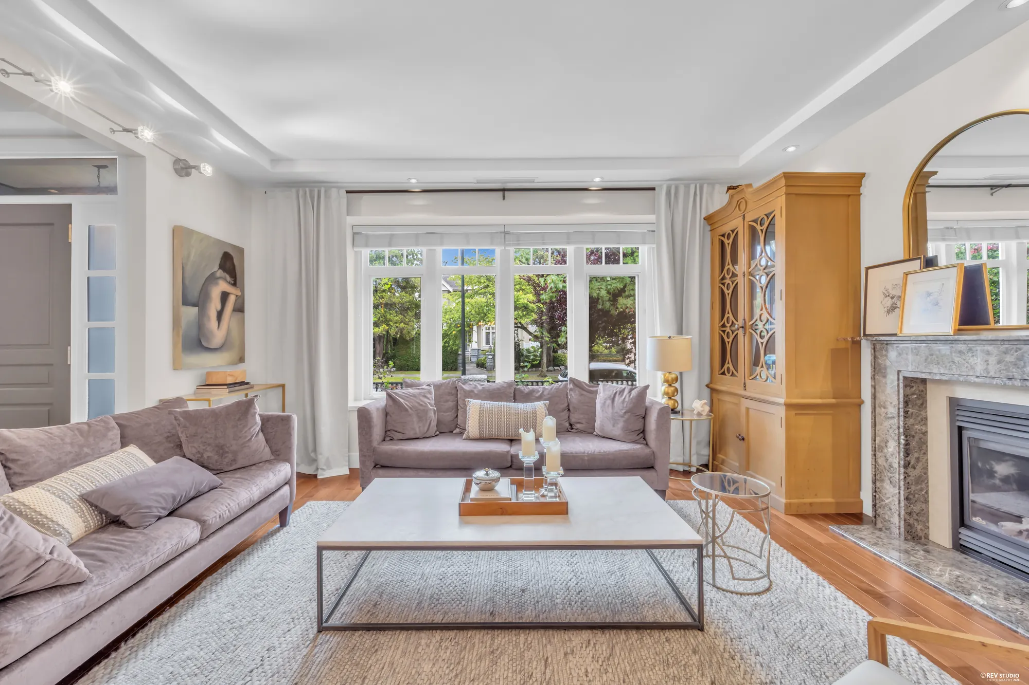 The living room toward its garden doors, the cabinet and fireplace at right