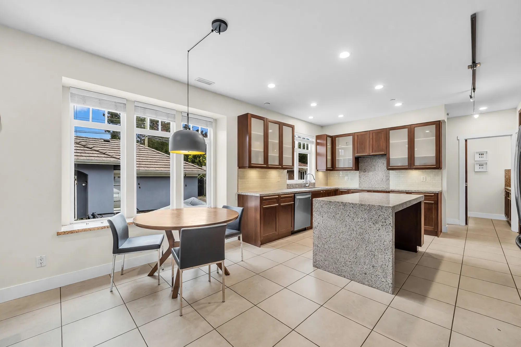 The breakfast nook: a round table by the window, the island and kitchen beyond