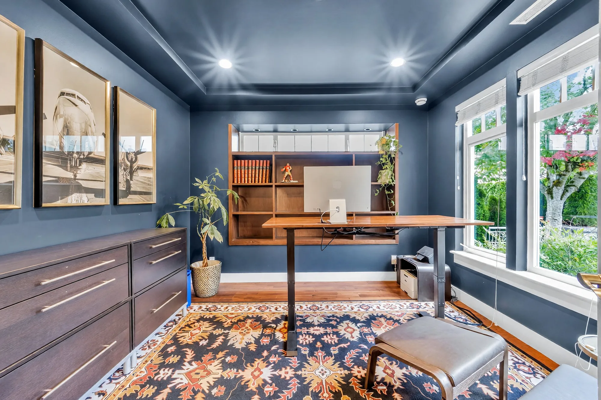 The office toward its shelves and the window, a chest of drawers along the left wall