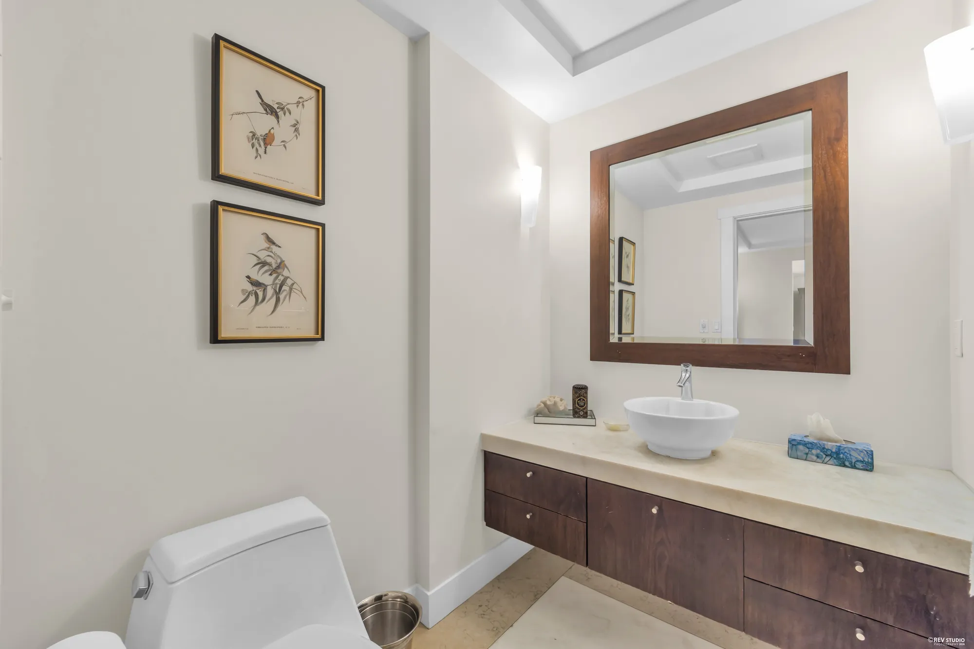 The powder room: a vessel basin on a floating vanity, a wood-framed mirror